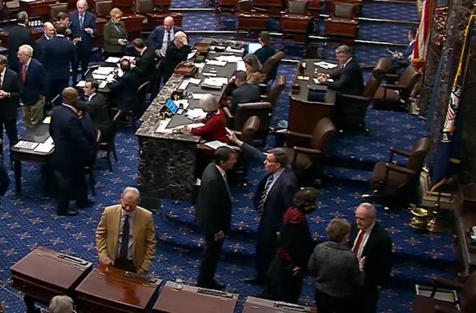 Senator Mark Warner raises his stretched out hand with the palm down, and on the floor of the Senate minutes after Kristi Noem's vote (on Saturday, Jan 25th, around noon, if you'd like to find it again yourself)
