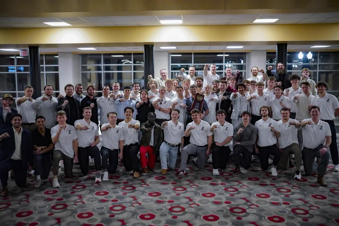 A picture of the UIndy men’s baseball team showcasing their 2024 Super Regional rings at the First Pitch Dinner.