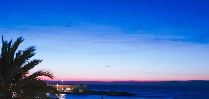 Barcelona seaside, in the early morning. The red sky in the background is turning blue.