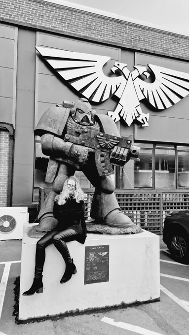 A black and white photo of Victoria in front of the Warhammer World Space Marine statue