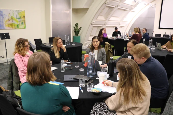 Group sitting at a table during a pitching session.