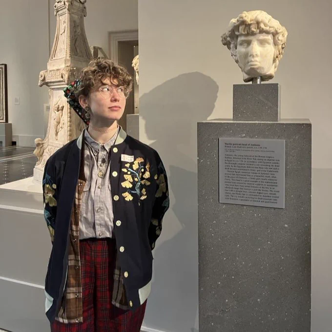 Talia at the Met looking at the head of Antinous in the guise of Dionysus.