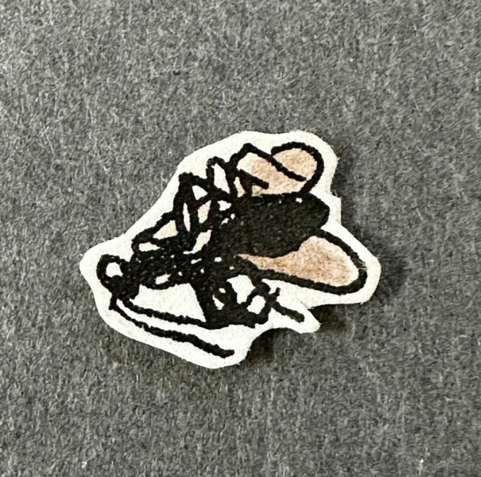 A miniature book that looks like an insect. Gray background.
