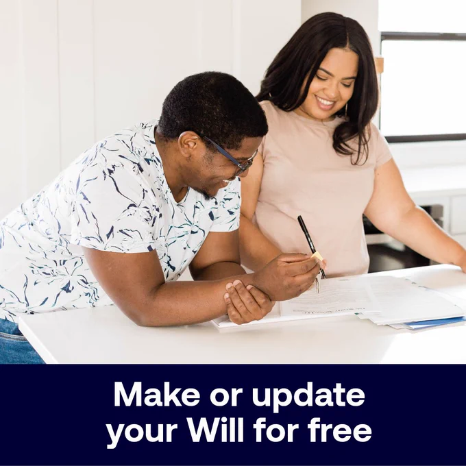 Two people standing next to each other, smiling and looking at documents.