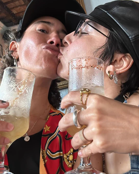 Selfie of Vico kissing Ane holding up drinks