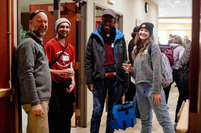 Four people stand together smiling for the camera, after being interrupted from their conversation. They are farmers from all across the state of Minnesota who gathered at the SFA Annual Conference.