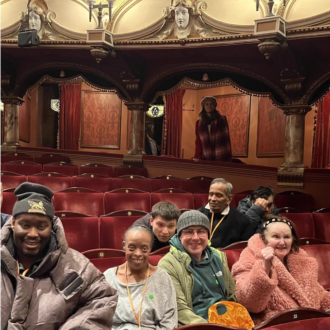 A group of Share students and a staff member sitting together in the audience at the London Coliseum.