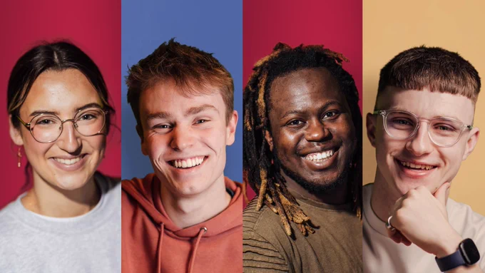 Four students each smiling broadly. The female student is standing in front of a red background. She is wearing glasses and a grey crewneck jumper. The male student next to her is standing in front of a blue background. He is wearing an orange hoodie. The male student next to him is standing in front of a red background. He is wearing a khaki t-shirt. The male student next to him is standing in front of a yellow background. He is wearing glasses and a cream t-shirt.