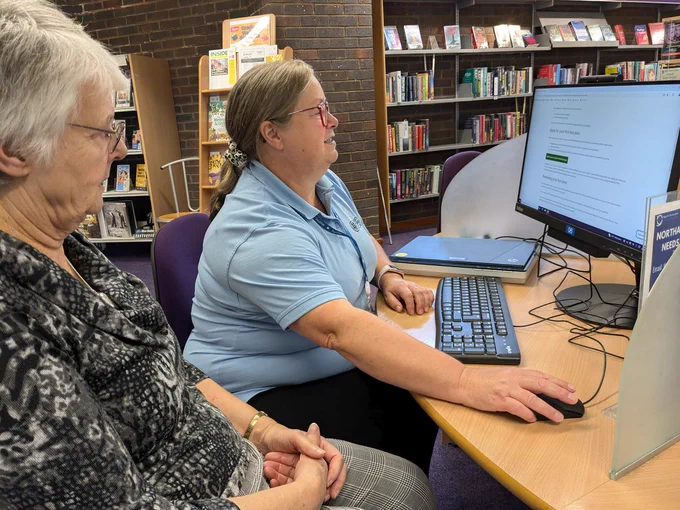 A woman being helped at a computer