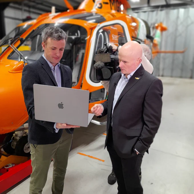 Researchers discuss a new data project in front of an air ambulance helicopter.