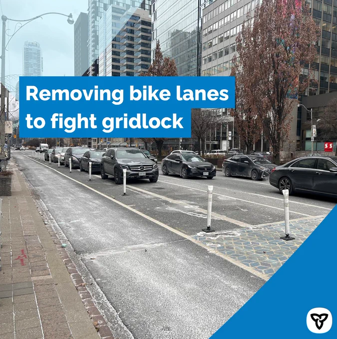 A busy urban street with heavy traffic and a row of parked cars next to a bike lane. The caption reads ‘Removing bike lanes to fight gridlock.’ 
