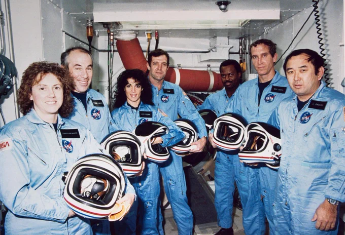 NASA's STS-51L crew members pose for photographs during a break in countdown training at the White Room, Launch Complex 39, Pad B. Left to right are Teacher-in-Space payload specialist Sharon Christa McAuliffe; payload specialist Gregory Jarvis; and astronauts Judith A. Resnik, mission specialist; Francis R. (Dick) Scobee, mission commander; Ronald E. McNair, mission specialist; Mike J. Smith, pilot; and Ellison S. Onizuka, mission specialist.

EDITOR'S NOTE: The STS-51L crew lost their lives in an explosion, onboard the space shuttle Challenger, following launch Jan. 28, 1986. Photo credit: NASA