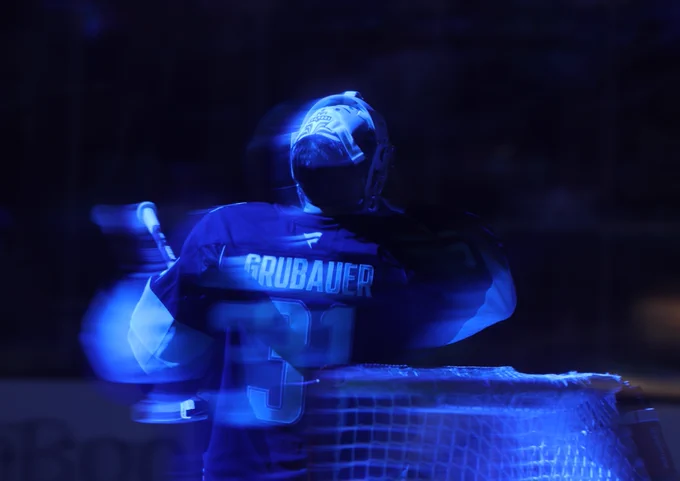 Slightly out of focus artsy photo of Philipp Grubauer on ice in a Kraken uniform.