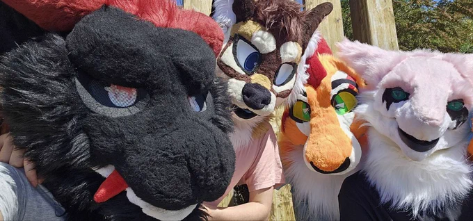 4 Fursuiters posing for a selfie/photo together