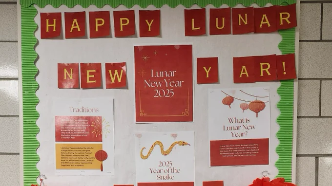 Bulletein board celebrating Lunar New Year, filled with zodiac information,  with red lettering and flowers.