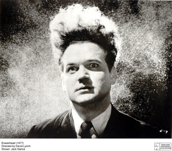 Actor Jack Nance in grainy black-and-white, his eyes wide and his hair combed up to stand tall and fluffy above his head. Image from 'Eraserhead', 1977.