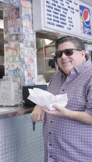 Governor Pritker holds a char dog from The Wiener Circle