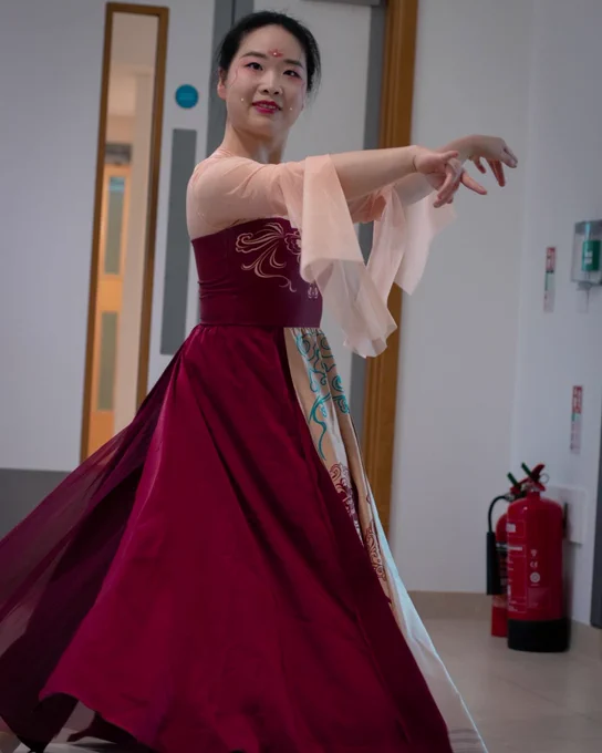 A performer in a red dress strikes a pose during their performance