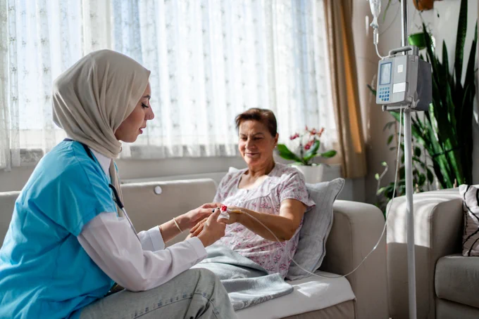 A clinician checks a patient's cannula in their home