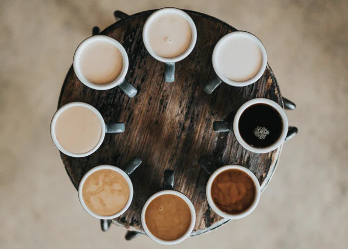eight coffee cups arranged in a circle on a circular table