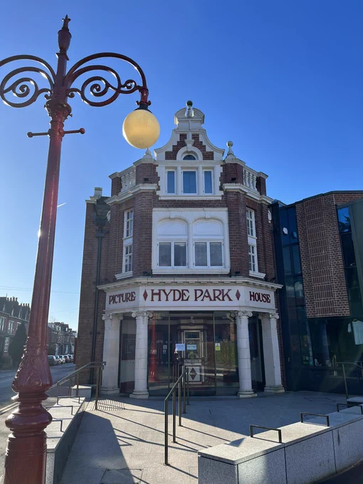 Exterior of Hyde Park Picture House, Leeds. A red brick building with large windows.