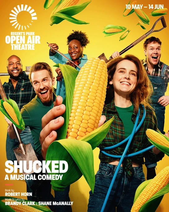 A large ear of corn is held front and centre as five people look excitedly toward the distance.