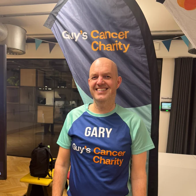 Gary at our Training Evening, standing in front of a Guy's Cancer Charity banner. 