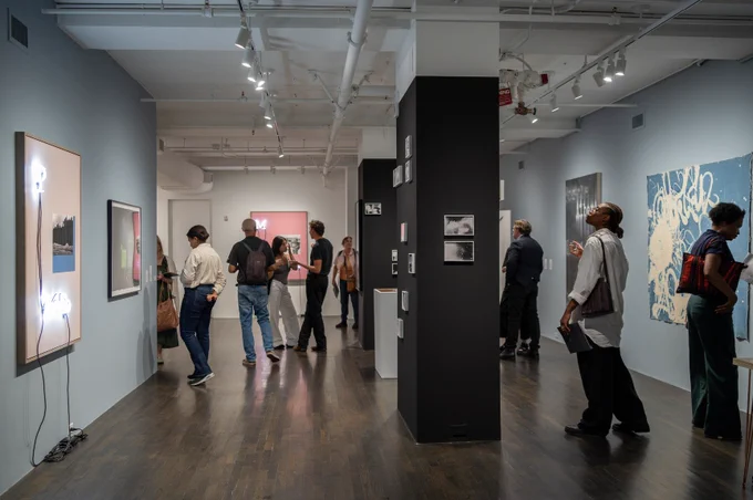 Image: Opening Reception of Scrawlspace, The 8th Floor, New York. September 2024. Photo by Gabrielle Beaumont.
 
Description:
 
A handful of people in an art gallery looking at various colorful textile, print, and installation works.
