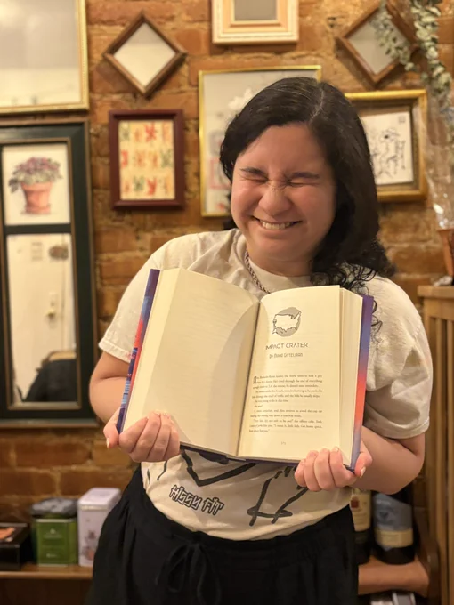 me smiling with the book open to my story, Impact Crater