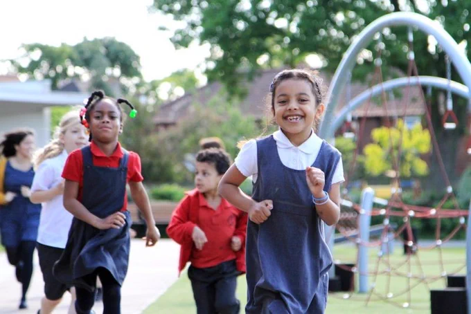 Children doing their Daily Mile in a playground.