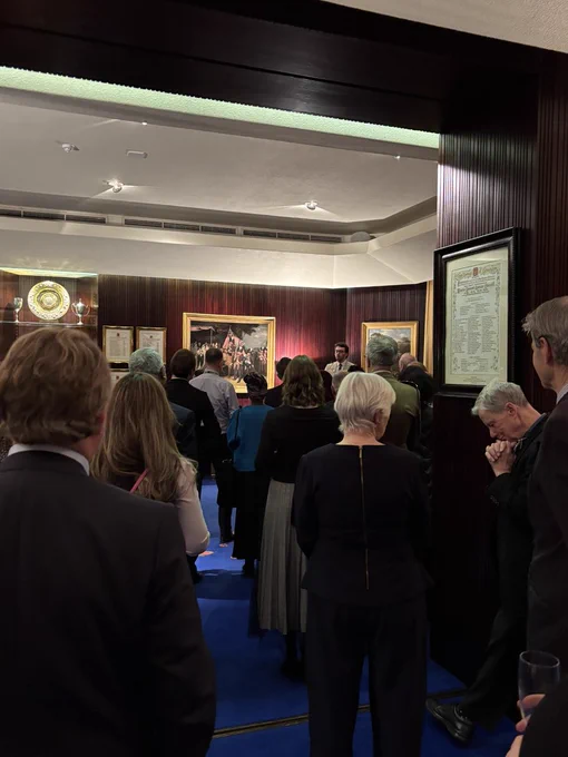 Photo of a crowd gathered inside the RBKC Mayor Parlour, listening to Mayor Will Lane give a small speech at his New Years reception.