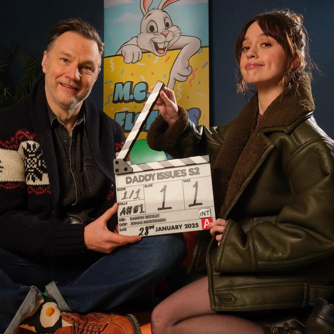 David Morrissey and Aimee Lou Wood sit side-by-side and hold a production clapperboard on the set of Daddy Issues series two. The board is dated 28 January 2025. 