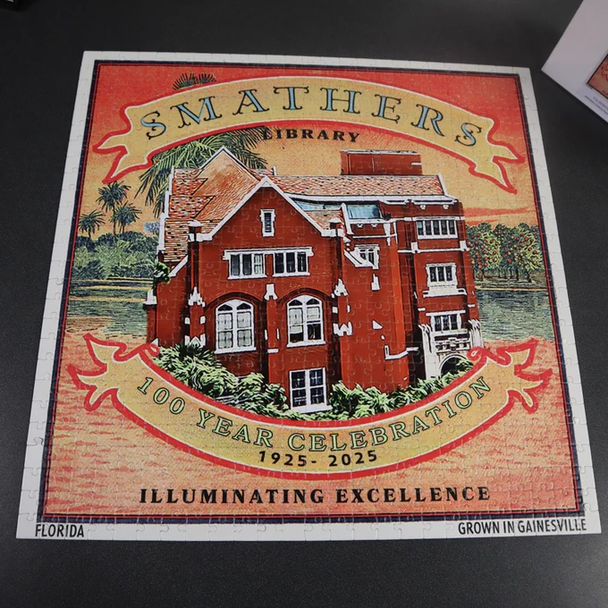 Completed jigsaw puzzle showing the Smathers Library building with banners "100 year celebration 1925 to 2025" Illuminating Excellence