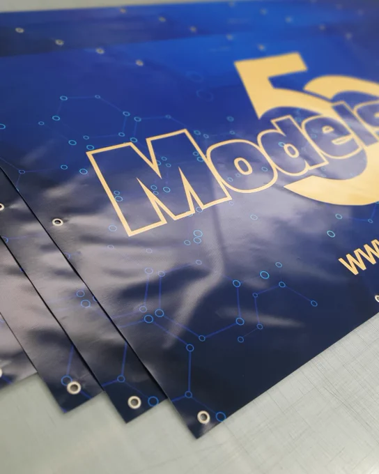 Modelsport 50th anniversary banners spread out on a workbench.