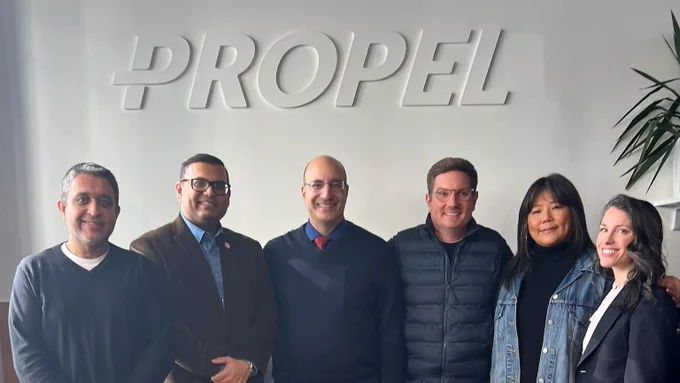 Deputy Public Advocate Hussain in a group photo with panelists, with the Propel logo on the wall above them