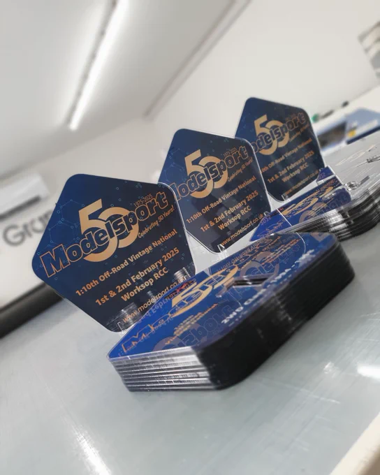 Finished acrylic trophies produced for Modelsport arranged on a workbench.