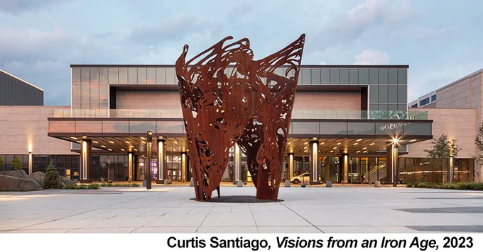 Image showing a large, perforated weathering steel sculpture located on a plaza.
