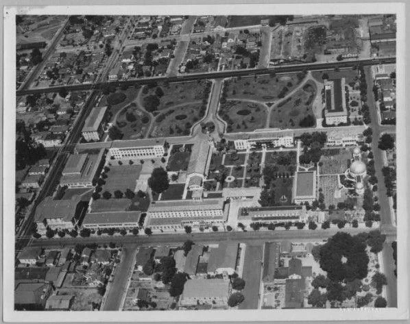Aerial black and white photograph of Santa Clara University campus and surrounding streets and buildings in the 1940s. 
