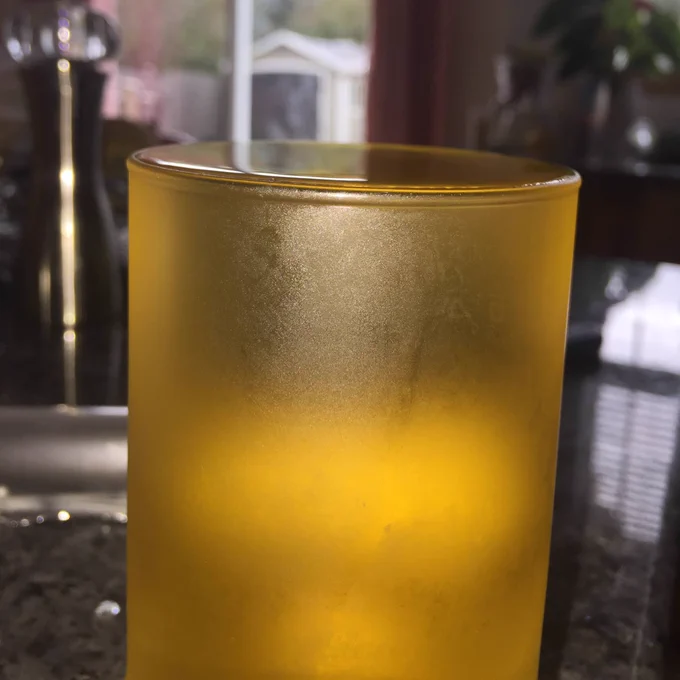 Cup of juice filled to the brim at a friends house 