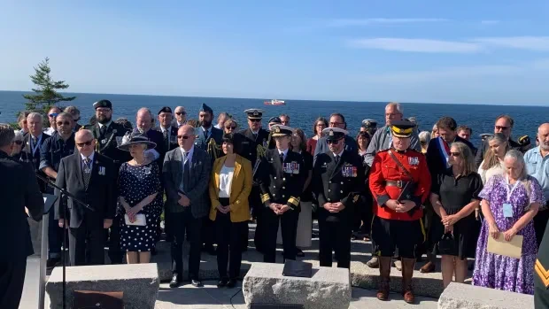 A few dozen people gather in a ceremony in 2025 at Peggy's Cove Swissair Memorial, marking 25 years since Flight 111 crashed offshore.
