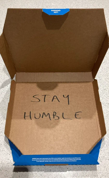 an empty pizza box with 'stay humble' written inside