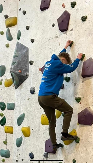 Teenager climbing on bouldering wall
