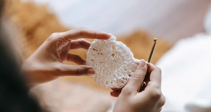 An image of two hands holding a crocheted circle.