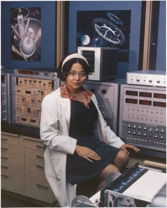 Patricia Cowings sitting on a stool in a white lab coat and looking directly at the camera.
