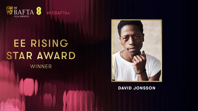 Designed graphic with pink fluted background and gold text that reads 'EE Rising Star Award Winner' with an image of actor, David Jonsson wearing a white t-shirt with his chin resting on his hand. 