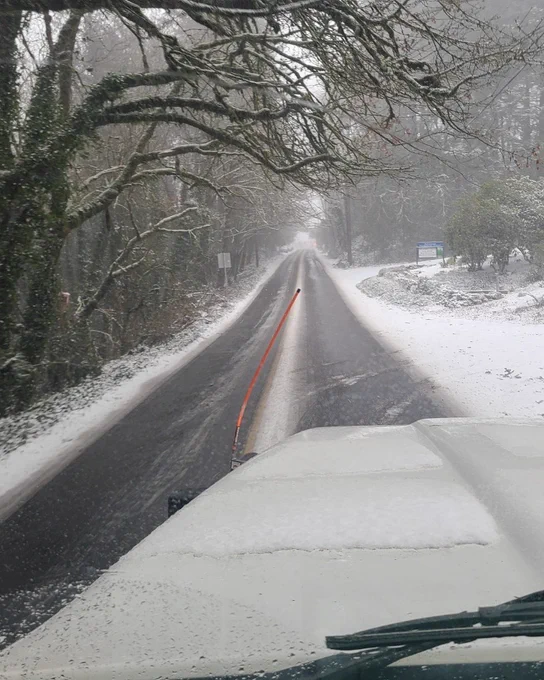 A snow plow drives on Portland streets in the blowing snow. 