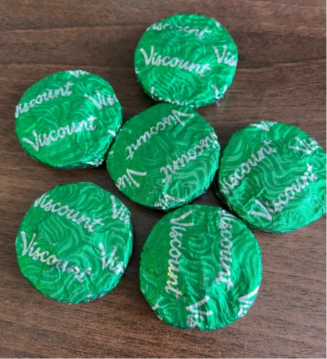 5 green shiny Viscount biscuits on a table.