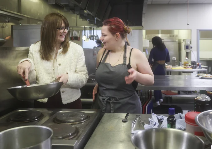 Economy Minister Dr Caoimhe Archibald in the Springvale training kitchen with Kayleigh Price, Skills for Life and Work catering student.