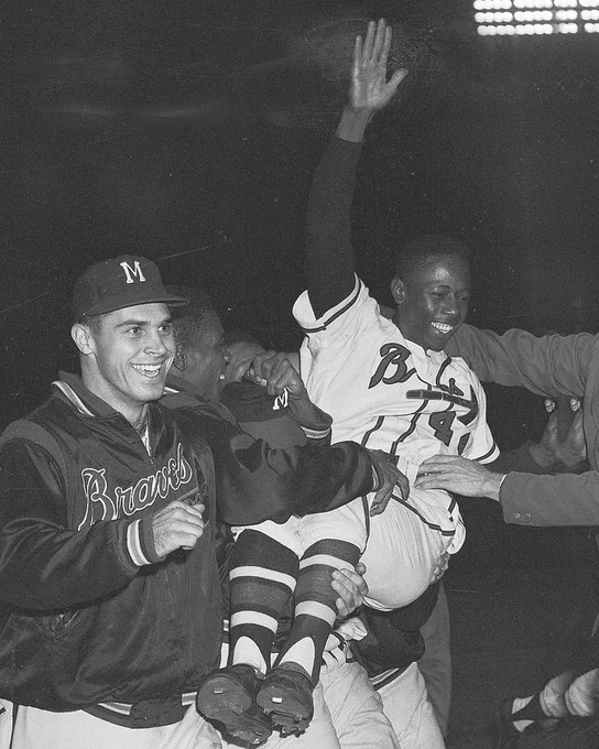 Hank Aaron is carried off the field by Braves teammates after hitting a walk-off home run against the Cardinals on September 23, 1957. 