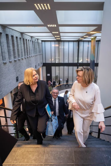 Ministerin Faeser und Exekutivdirektorin De Bolle steigen nebeneinander eine Treppe hinauf und unterhalten sich.